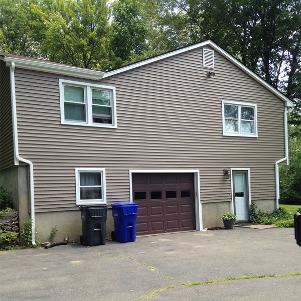 Two-story home with taupe siding and white gutters